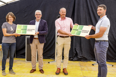 Am Dorf- und Naturpark-Fest am 31. Juli 2022 in Tenna wurde das Label feierlich von Herrn Dr. Hans Romang vom Bundesamt für Umwelt in symbolischer Form an die Trägergemeinden des Naturpark Beverin übergeben. Regierungsrat Jon Domenic Parolini überbrachte persönlich die Glückwünsche des Kantons Graubünden. Eine Frau und ein Mann sowie zwei Männer halten je eine Holztafel mit den Naturpark-Logo.