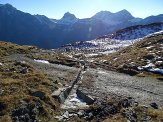 Erneuerter Steinplatten-Querabschlag unterhalb der Passhöhe, mit Panoramablick auf Schwarzhorn, Pizzas d'Anarosa, Alperschällihorn und Weisshorn. 