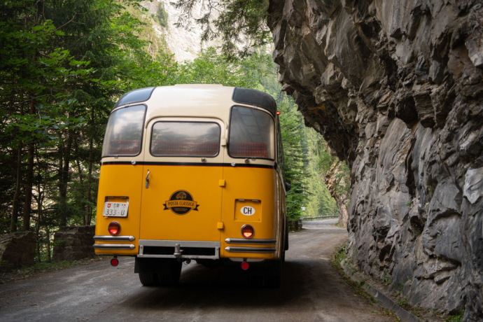 Im Rahmen des 200 Jahre Commercialstrasse Jubiläums fuhr ein historisches Postauto durchs Verlorna Loch. Historisches Postauto auf enger Bergstrasse am Fels