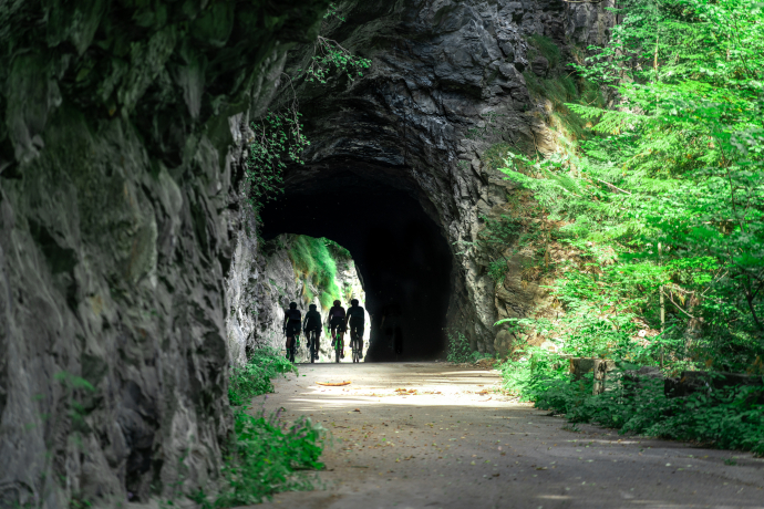 Velofahrer beim Verlorna Loch (Bild: GRF TolisArt.com) Vier Velofahrer in einem Tunnel auf einer Bergstrasse